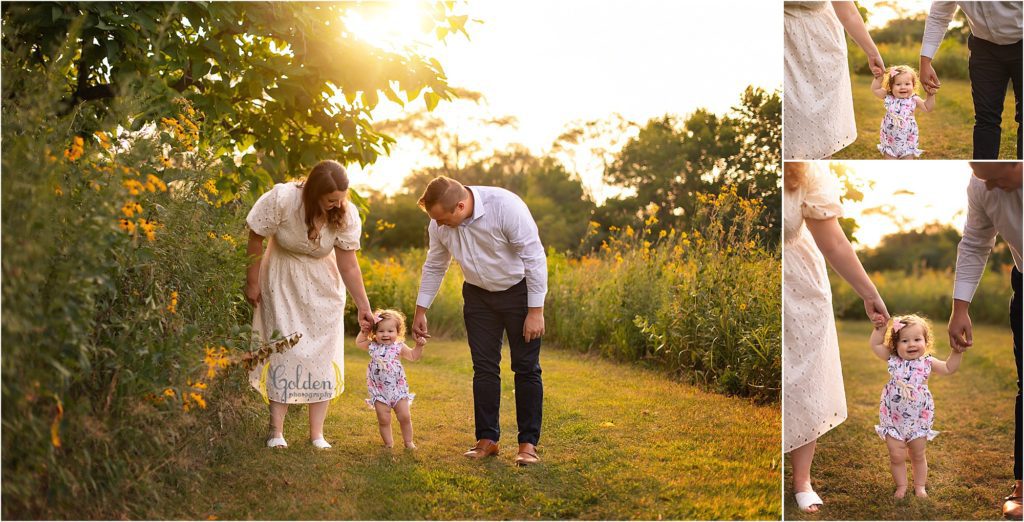 parents holding 1 year olds hands at sunset in Illinois