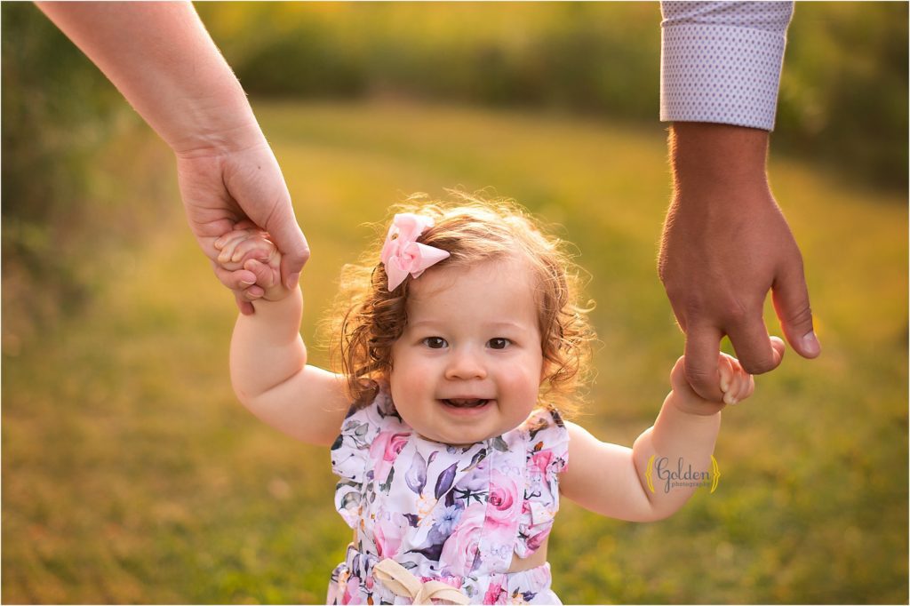 1 year old little girl smiling outdoors