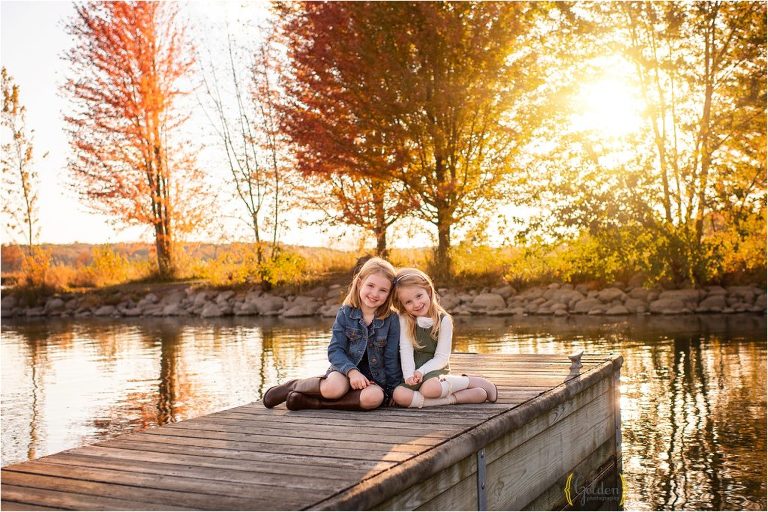 sisters sitting on a Lake County IL dock at sunset