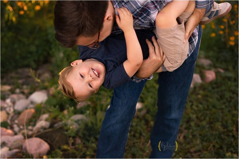 dad holding son upside down for family photos