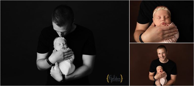 dad holding newborn baby girl in a photography studio