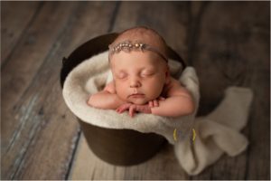 baby girl asleep in a bucket in Chicago suburbs photography studio