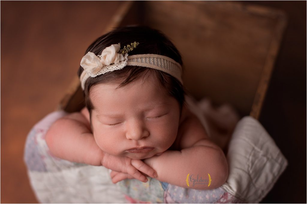 close up of newborn sleeping in crate for photography session