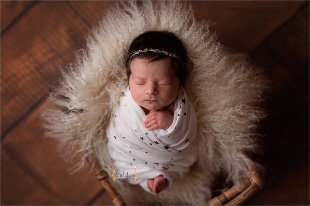 baby swaddled in star fabric sleeping in a wooden crate for photography session near Crystal Lake IL