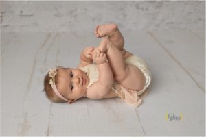 baby girl reaches for toes in Lake Zurich IL photo studio