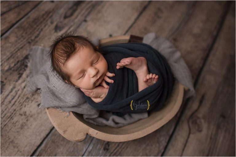 swaddled baby boy in bowl for newborn photo session near Highland Park IL