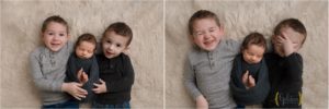 big brothers holding newborn boy in Lake Bluff IL photography studio