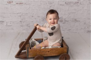 child smiling in a wooden create in Grayslake IL photography studio