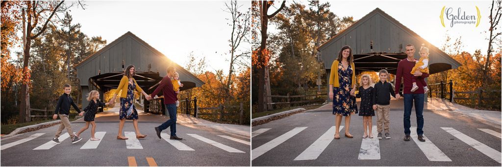 family posed in front of Long Grove covered bridge for photo session