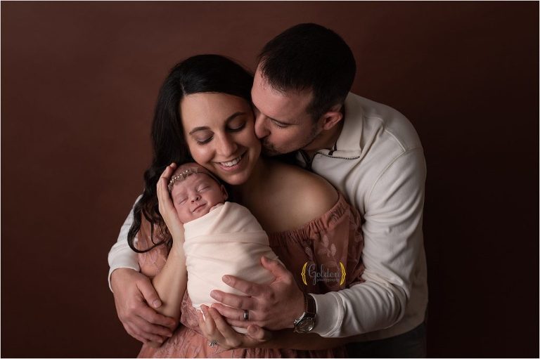 parents holding baby girl for family photos in a studio near Arlington Heights IL