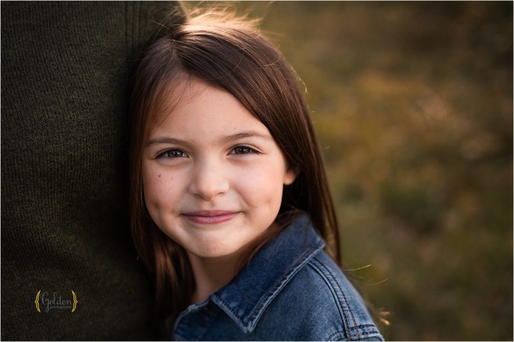 older girl hugging dad's side for family photos