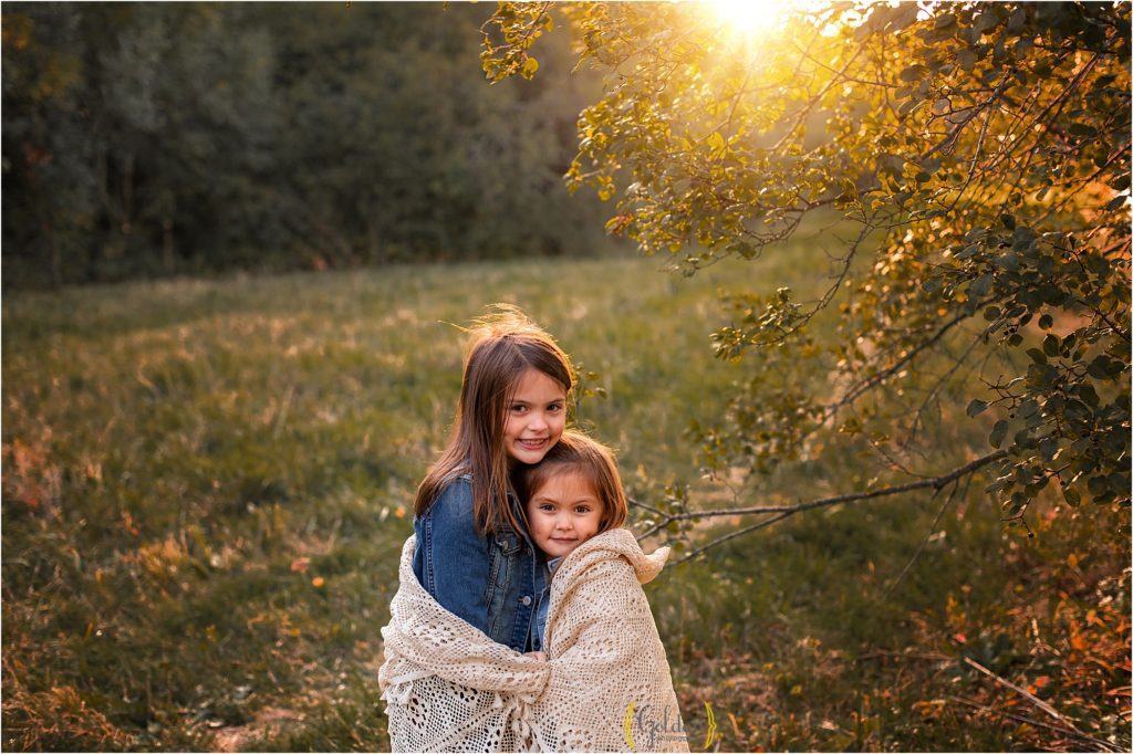 siblings wrapped in a blanket in a Schaumburg IL park for family photography