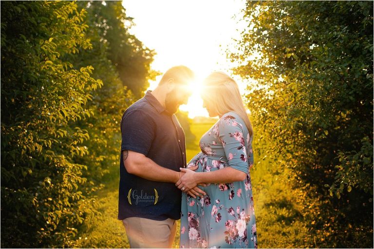 sun flare covering pregnant couple during maternity photography session
