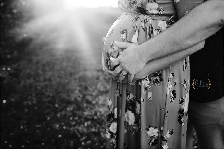 black and white of dad holding wife's belly for maternity photos