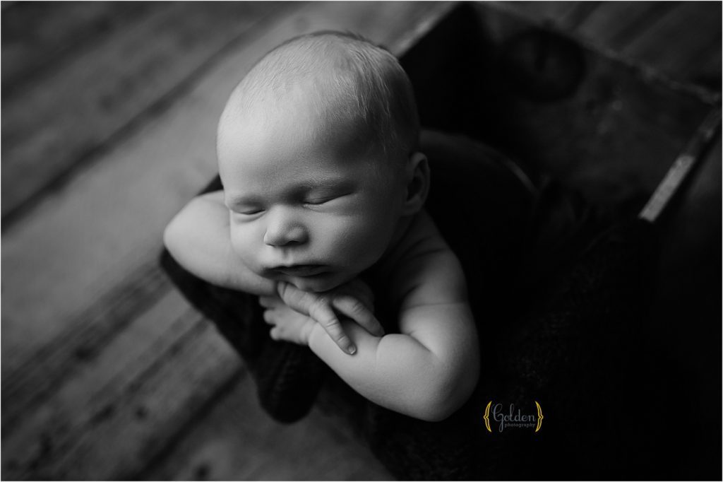 black and white of boy posed on wooden box