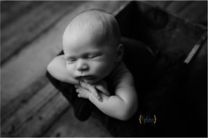 black and white of boy posed on wooden box