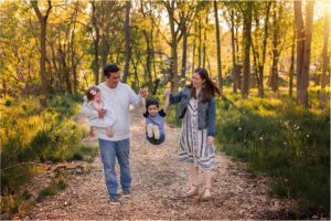 family walking and swinging child during family photography near Barrington IL