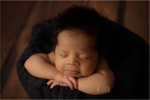baby boy posed in bucket for newborn photography in Chicago IL
